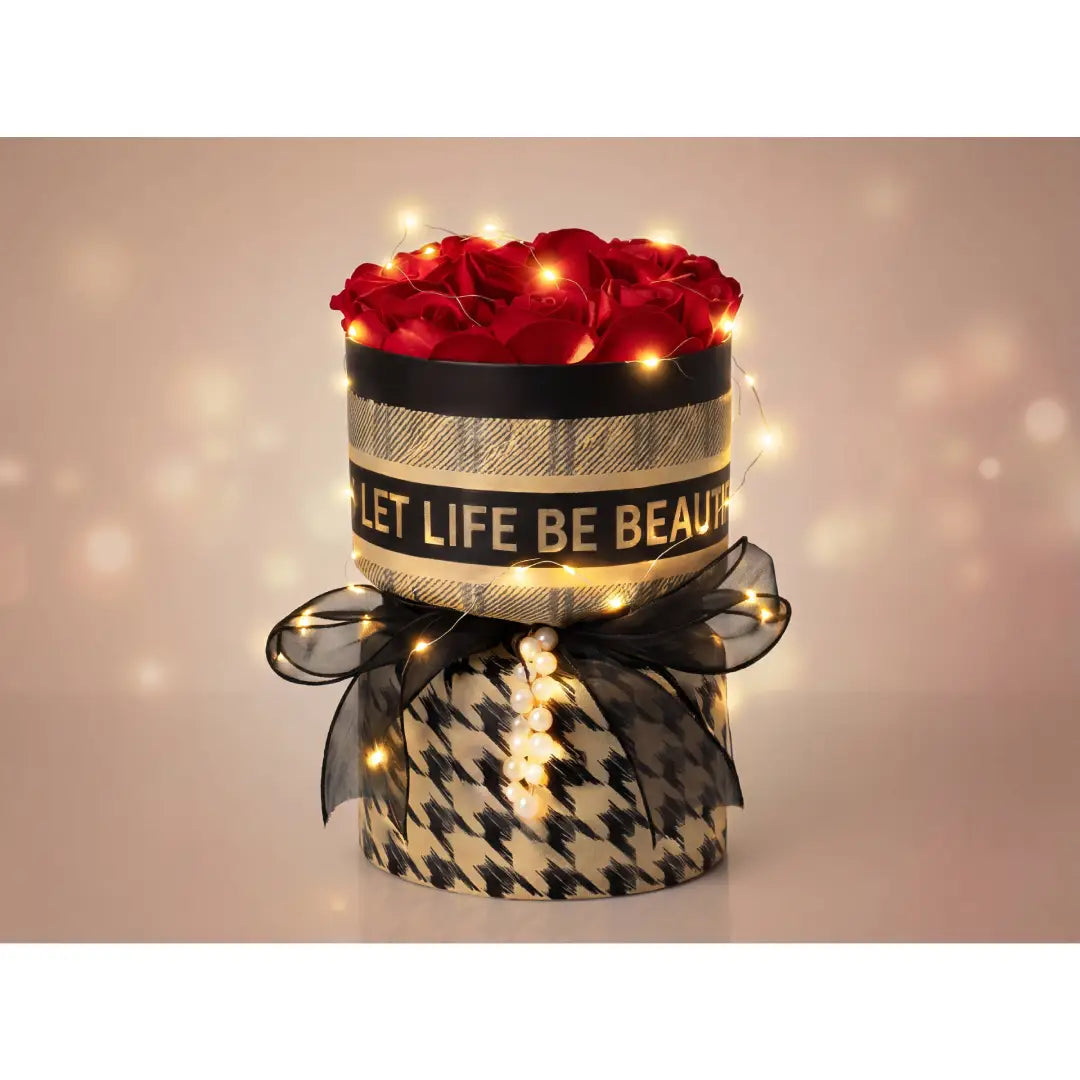 Ronde luxe rozenbox met rode rozen, warme LED verlichting, zwarte strik en elegant patroon