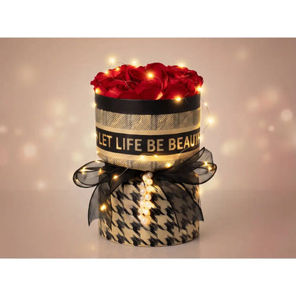 Ronde luxe rozenbox met rode rozen, warme LED verlichting, zwarte strik en elegant patroon