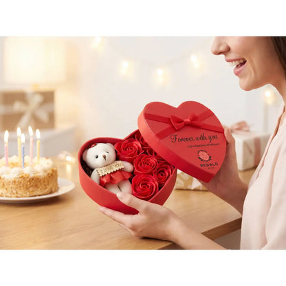Vrouw opent luxe hartvormige rozenbox met teddybeer als romantisch cadeau